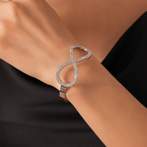 Dettaglio ravvicinato di un bracciale infinito in argento con cristalli di zircone al polso