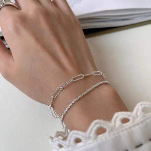 Dettaglio del bracciale a catena a strati in argento S925 sul polso di una modella