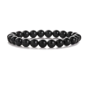 Detail view of 8mm matte black wood and agate beads bracelet on a white background