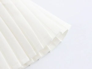 Makro-Detail von weißem Faltenrock mit Spitze, zeigt Stofftextur und feine Nähte am Saum