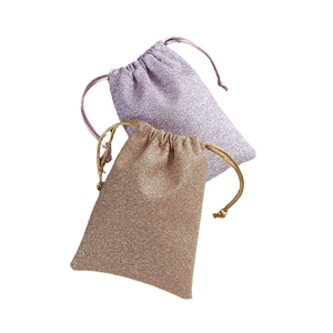 Glitter drawstring jewelry pouches in lavender and champagne gold on white background