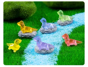 Macro detail of six colorful miniature resin lizards on stones in a tiny landscape