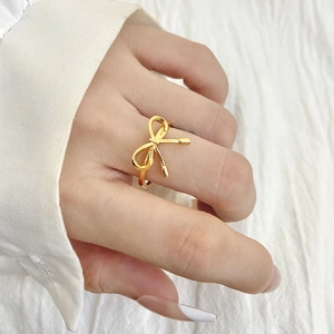 Bague nœud dorée élégante pour femme avec un design ajouré minimaliste sur le doigt