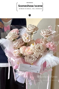 Person holding a large bouquet with roses and white ostrich feathers for flower decoration