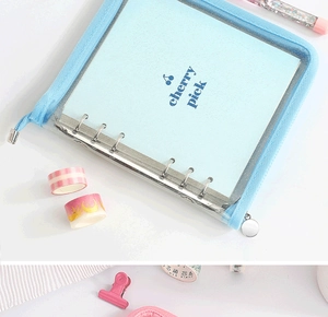 Detail view of light blue glitter PVC binder cover with six-ring metal mechanism and zipper
