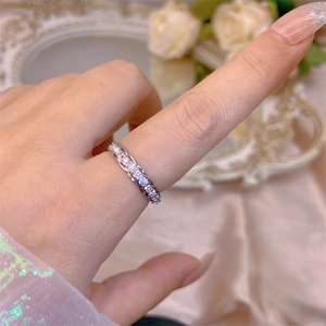 Close-up of sparkling cubic zirconia open ring with silver interwoven band design
