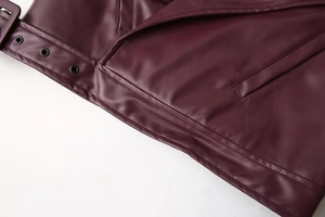 Detail der weinroten Lederjacke mit Metallösen und hochwertigen Nahtstrukturen