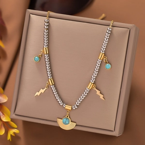 Detailed beaded necklace with gold lightning bolt and turquoise pendant on jewelry box