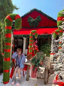 Detailed view of blue gingham cardigan with red heart appliques in a festive outdoor setting