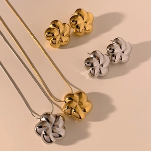 Detail view of hollow flower necklaces and earrings in gold and silver finishes
