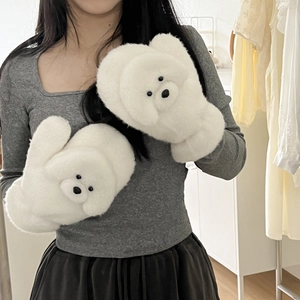 Gros plan de moufles blanches en peluche au design Bichon mignon et texture douce
