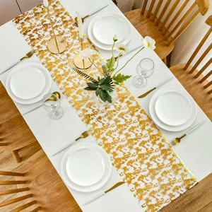Detailed top view of gold foil mesh table runner on a white table with festive tableware