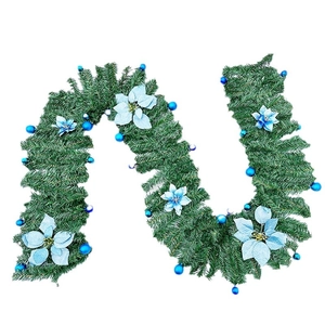 Green Christmas garland with blue poinsettias and ornaments on a white background