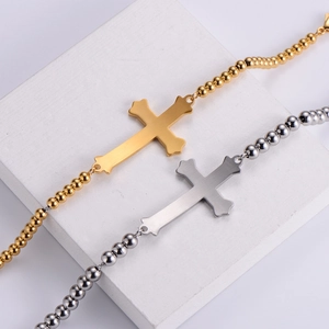 Detail of silver and gold cross beaded bracelets with brushed and polished metal textures