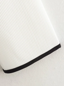 Macro detail of white ribbed fabric with black contrast binding and stitching quality