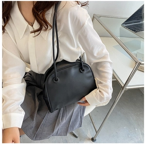Minimalist black matte leather Boston tote bag styled in a professional office setting