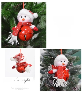 Detail view of a red metal Christmas bell with a plush snowman head and polka dot hat