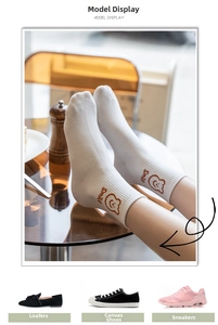 Detailed close-up of white crew sock with bear embroidery and smile lettering
