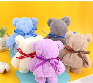 Detail of five cute bear-shaped towels in mixed colors with decorative bow ribbons