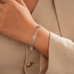 Detailed view of 18k gold plated hollow flower bangle with zircon stones on wrist