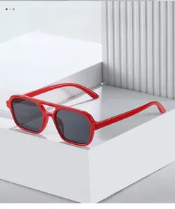 Detail of red pilot sunglasses with double bridge design on a geometric white pedestal