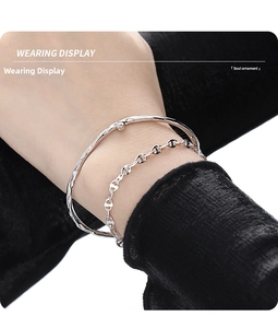 Detail of silver layered bracelet set with micro diamonds and anchor chain on wrist