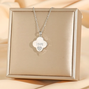 Silver steel clover necklace with LOVE engraving and heart zircon pendant on jewelry box