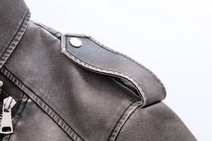 Détails de la veste en cuir noir vintage avec fermetures éclair et boutons pression