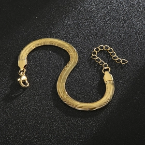 Close-up of golden snake bone chain bracelet with lobster clasp on black background