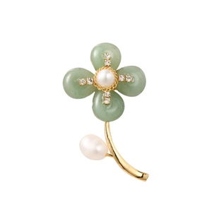 Close-up of shell floral brooch with green petals, white pearls and gold accents