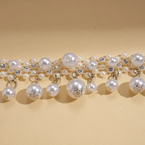 Detail of baroque pearl sweater chain featuring rhinestone accents and drop pendants