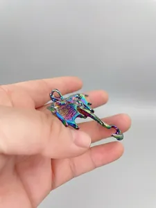 Detail of the colorful iridescent enamel dragon brooch with metallic rainbow finish