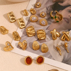 Flat lay of vintage 18K gold plated earrings with red agate and geometric star designs