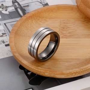 Matte silver titanium steel men's ring with double black beveled lines on a wooden tray