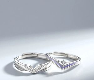 Close-up of V-shaped couple rings in silver and purple with sparkling zircon accents