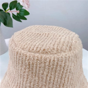 Close-up of the plush texture on the cream-colored faux shearling bucket hat