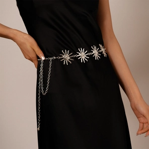 Detail of silver sun relief chain belt featuring embossed faces on metallic discs
