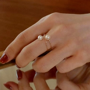 Close-up of double pearl open ring in rose gold with elegant twisted rope band texture
