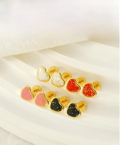 Detail of sweet heart-shaped earrings in four colors with gold polka dot patterns