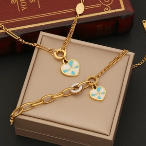 Set collana e bracciale a cuore in acciaio dorato con smalto blu e bianco chic