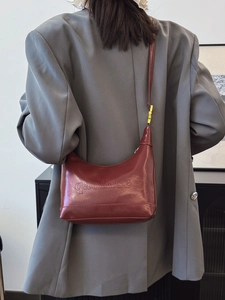 Chic burgundy faux leather shoulder bag with gold hardware and embossed logo