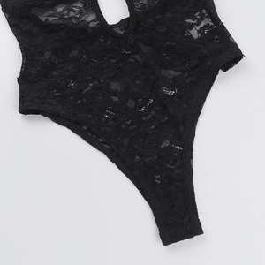 Detailed close-up of intricate black floral lace texture on sexy cut-out jumpsuit