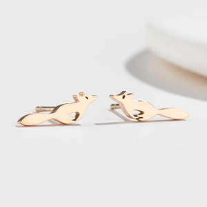 Detailed view of fox-shaped rose gold stud earrings with polished metallic finish