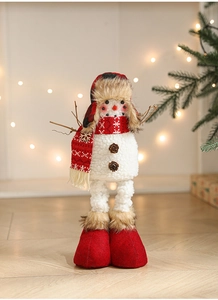 Detail of Christmas snowman plush with plaid hat and branch arms in festive lighting