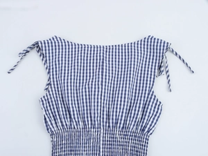 Detail of blue and white plaid dress with smocked elastic design and shoulder ties