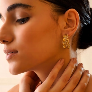 Textured 18K gold stainless steel chunky hoop earrings with wavy design on model