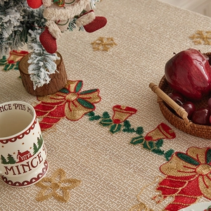 Close-up of Christmas tablecloth with embroidered bells and festive jacquard texture