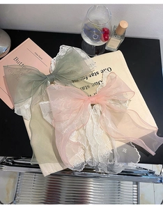 Pink and sage green lace mesh bow hair clips set against a minimalist aesthetic backdrop