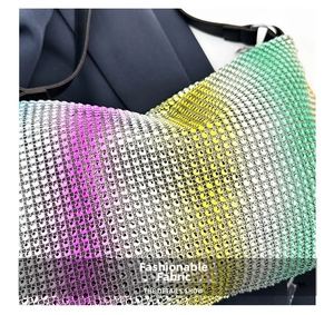 Close-up of vibrant gradient rhinestones on fashion handbag with metallic mesh texture