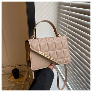Dettaglio borsa trapuntata beige in finta pelle con finiture dorate in luce naturale